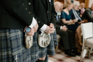 Person in tartan Argyll jacket and kilt at a Scottish festival.